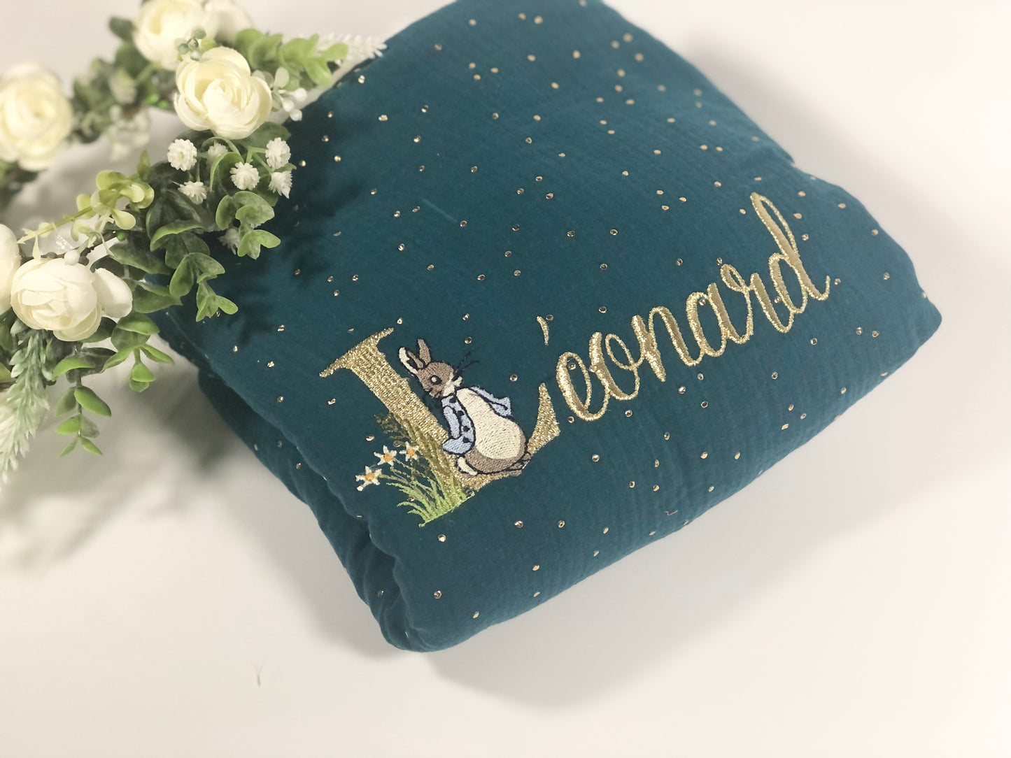 La couverture gaze vert paon et initiale Peter Rabbit