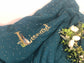 La couverture gaze vert paon et initiale Peter Rabbit